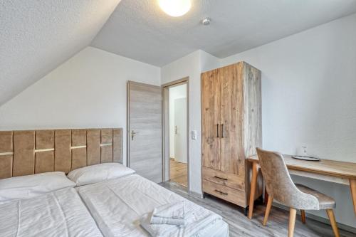 a bedroom with a bed and a desk and a chair at Werrapark Resort Hotel Frankenblick in Masserberg