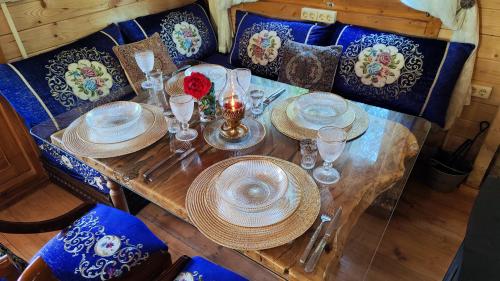 a table with plates and glasses on top at Refugio madera estilo árabe con estatuas, estanques y un pequeño zoo in Albacete
