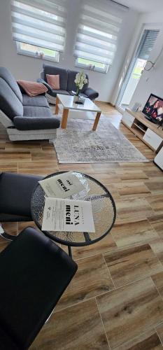 a living room with a table and a couch at Apartman Deny in Sanski most