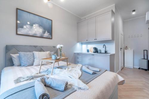 1 Schlafzimmer mit einem Bett mit einem Tisch und einer Küche in der Unterkunft Piekary Residence in the Center - 18 in Posen