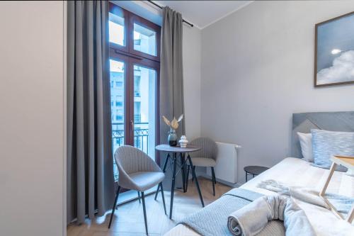 ein Schlafzimmer mit einem Bett und einem Tisch und Stühlen in der Unterkunft Piekary Residence in the Center - 18 in Posen