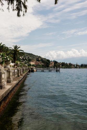 a body of water with a pier in the distance at Grand Hotel Fasano in Gardone Riviera