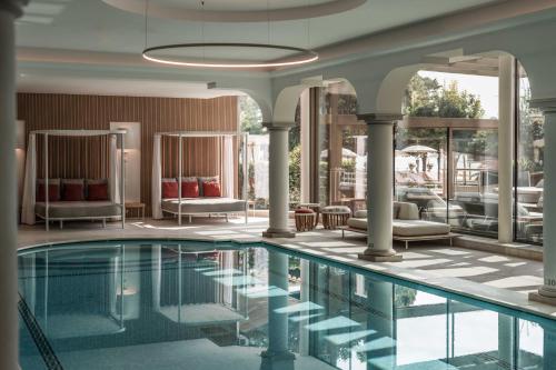 a swimming pool in a hotel with chairs and tables at Grand Hotel Fasano in Gardone Riviera