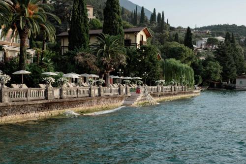 a body of water with buildings and trees and a river at Grand Hotel Fasano in Gardone Riviera