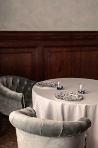 a table and a chair with a table and two glasses at Grand Hotel Fasano in Gardone Riviera