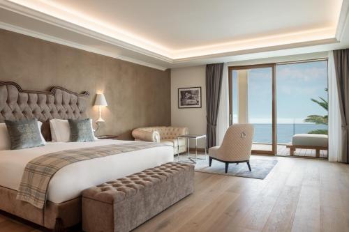 a bedroom with a large bed and a large window at Grand Hotel Fasano in Gardone Riviera
