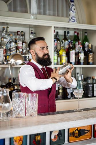 a man standing behind a bar preparing a drink at Grand Hotel Fasano in Gardone Riviera