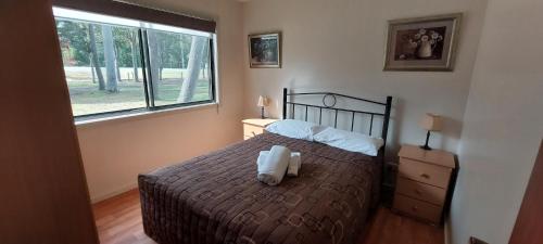 a bedroom with a bed with two towels on it at Sale Caravan Park in Sale