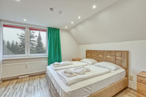 two beds in a bedroom with green curtains at Werrapark Resort Hotel Frankenblick in Masserberg
