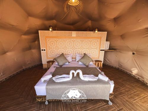 a bedroom with a large bed in a yurt at Royal Sahara Dome Camp in Merzouga