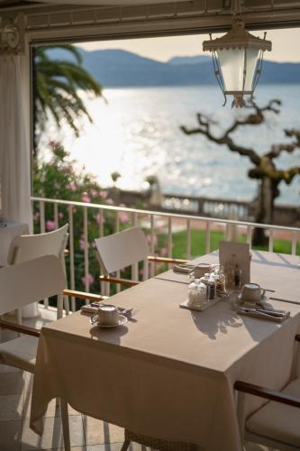 a table and chairs with a view of the ocean at Grand Hotel Fasano in Gardone Riviera
