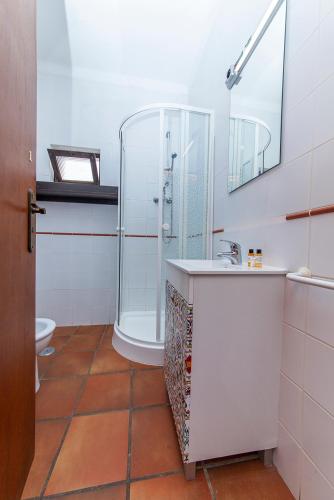 a bathroom with a shower and a sink at Casa do Farol Guesthouse in Lagos