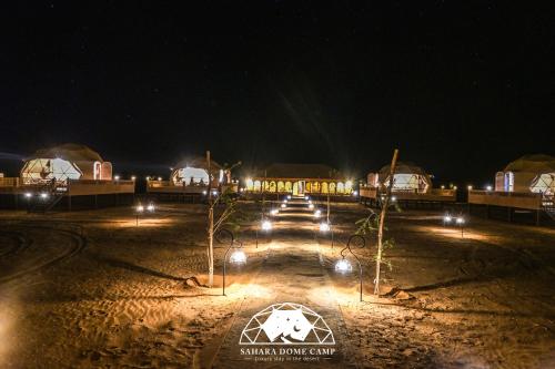 a group of lights in a field at night at Royal Sahara Dome Camp in Merzouga