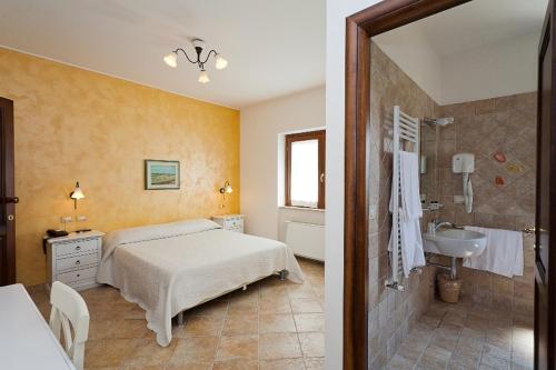 a bedroom with a bed and a bathroom with a sink at Corte In Fiore in Ardea