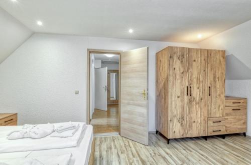 a bedroom with a bed and a wooden cabinet at Werrapark Resort Hotel Frankenblick in Masserberg