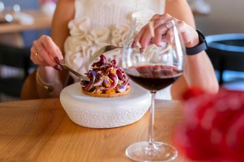 a woman cutting a dessert with a glass of wine at Ca' Bonfadini Historic Experience in Venice