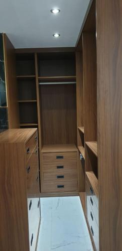 a walk in closet with wooden cabinets and drawers at CENTRO, PARKING, PISCINA 2 Dormitorios SUITE PONDOS in Linares