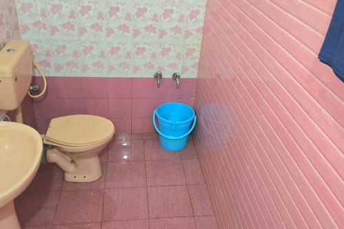 a bathroom with a toilet and a blue bucket at Entire 4 Bedroom Villa in Kannur in Edakkād