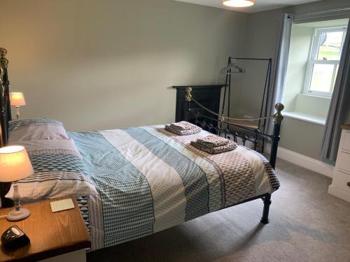 a bedroom with a bed and a table and a window at White Lea in Grinton