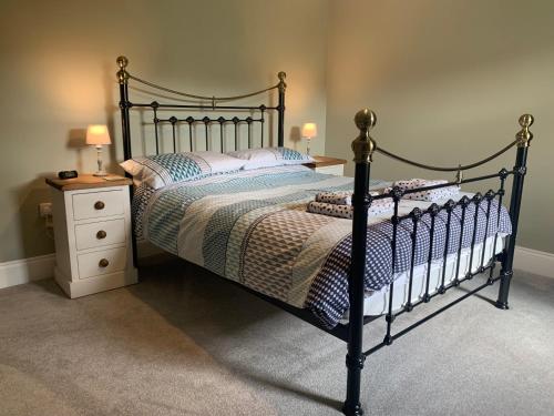 a bedroom with a black bed and a night stand at White Lea in Grinton
