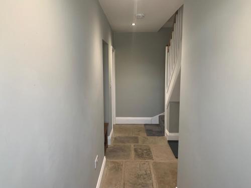 a hallway with white walls and a tile floor at White Lea in Grinton