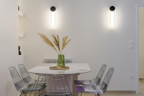 アテネにあるKoukaki Cielo Villa10 -Pvt Yard 3BR 8ppl -10min Metro Acropolisの白いテーブルと椅子のあるダイニングルーム