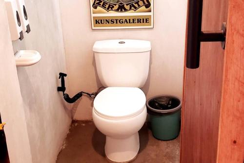 a bathroom with a toilet and a sign on the wall at Duon Baler - Seconds from Sabang beach, your peaceful escape in Baler