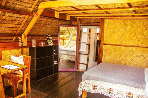 a bedroom with a bed and a table in a room at Duon Baler - Seconds from Sabang beach, your peaceful escape in Baler