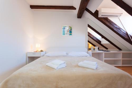 ein Schlafzimmer mit einem großen Bett mit zwei Handtüchern darauf in der Unterkunft Apartment Melano A5 in Dubrovnik