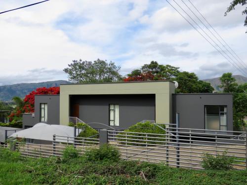 a house with a fence in front of it at The Executive - Exclusive Self-Catering Apartments - Ezulwini in Ezulwini