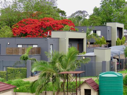 a row of houses with red flowers at The Executive - Exclusive Self-Catering Apartments - Ezulwini in Ezulwini