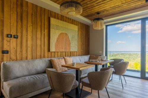 a living room with a couch and a table and chairs at The Pines Bucegi Lodge in Bran