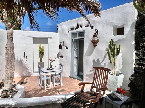 ein weißes Haus mit einem Tisch und Stühlen auf einer Terrasse in der Unterkunft La 'Casita ALOE' Ferien in historischer Finca am Rande der Vulkane im schönen Dorf Uga in Uga