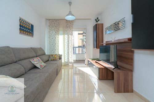 ein Wohnzimmer mit Sofa und Fernseher in der Unterkunft Bonito apartamento cerca de playa in El Campello