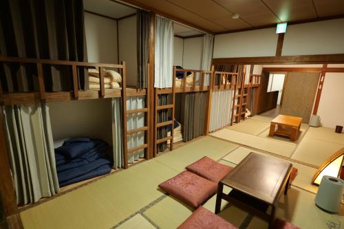 a room with two bunk beds and a couch at yol Guesthouse ヨルゲストハウス in Takeo
