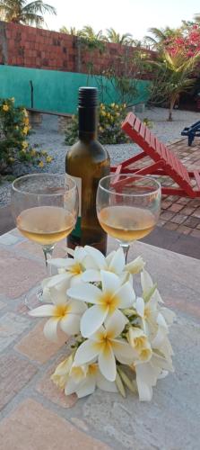 two glasses of wine next to a bouquet of flowers at Village Lagoinha Ceará in Tigre