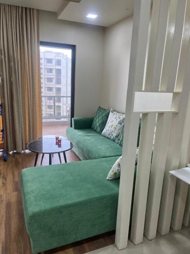 a living room with a green couch and a table at 3 BHK exclusive suite in Nashik