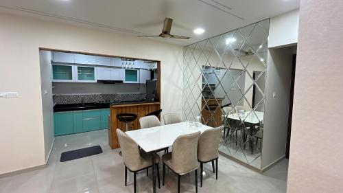 a kitchen and dining room with a white table and chairs at 3 BHK exclusive suite in Nashik