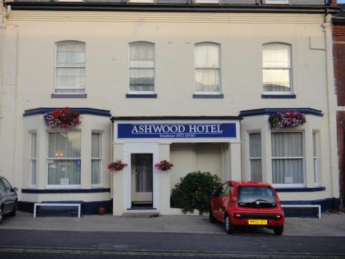 a red car parked in front of a aswegian wood hotel at Ashwood Hotel in Preston
