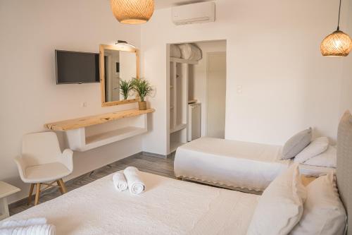 a living room with two beds and a desk at Christiana Hotel in Ambelas