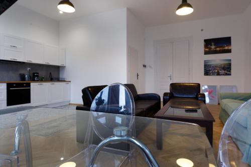 a living room with a glass table and chairs at Apartament na Granicy 5 in Cieszyn
