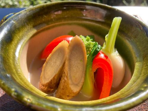 a bowl of soup with meat and vegetables in it at HOTEL LT Kitchen Yugawara in Yugawara
