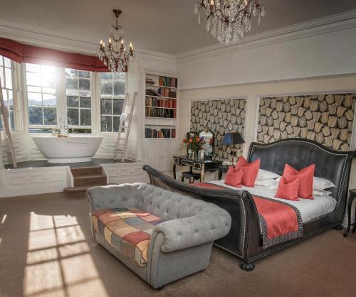 a bedroom with a bed and a chair and a tub at Château Rhianfa in Menai Bridge