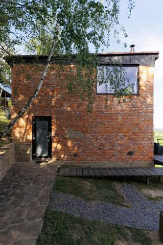 a brick building with a door and a window at Vdoma Karpaty in Vilshynki