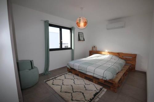 une chambre avec un lit en bois et une fenêtre dans l'établissement Belle villa contemporaine climatisee, piscine privee, 6 - 8 couchages, 3 chambres, wifi, à 3 km de la plage -LXDALI25B, à Portiragnes