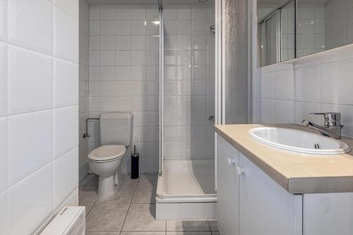 ein weißes Badezimmer mit Toilette und Waschbecken in der Unterkunft Galathea B0303 in Oostduinkerke