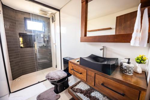a bathroom with a sink and a shower at Cabana Perfeita a 800m da Praia - Lareira externa, Quintal Amplo, Pet Friendly, Ar condicionado, Netflix e Conforto completo in Imbituba