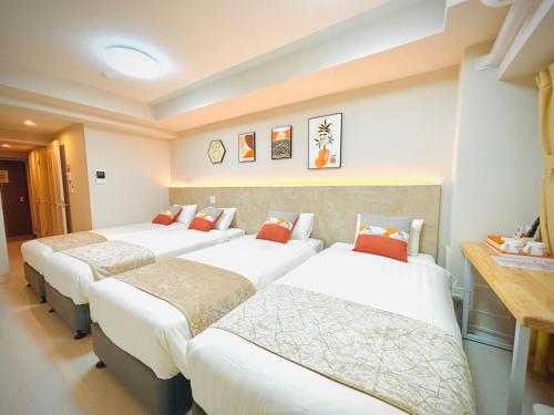a row of beds in a hotel room at Hotel Arashi Nambaminami No003 in Osaka