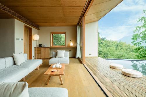 a living room with a couch and a table at 大山初里 Origin Villa Village Hotel&Resort in Tonglu