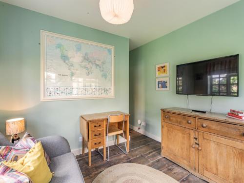 a living room with a couch and a tv and a desk at Uk44005 - Carters Yard in Kimbolton